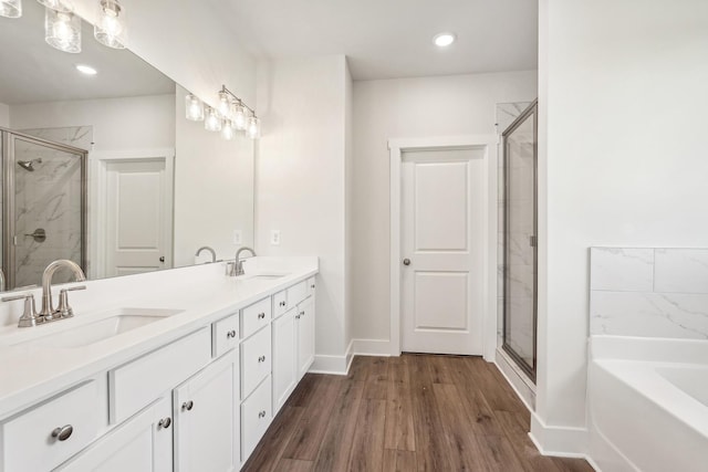 bathroom featuring vanity, plus walk in shower, and wood-type flooring