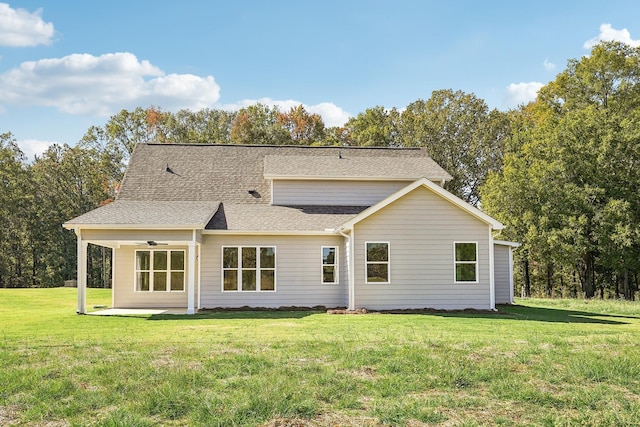 rear view of house featuring ceiling fan, a yard, and a patio