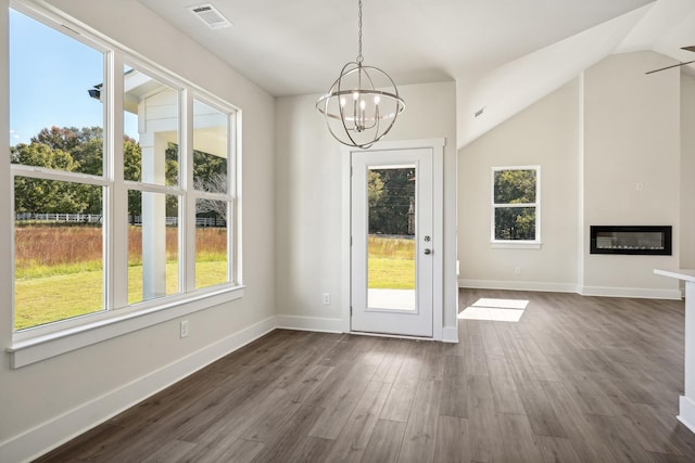 doorway with dark hardwood / wood-style flooring, a chandelier, and vaulted ceiling