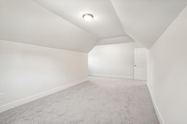 bonus room with vaulted ceiling and carpet floors