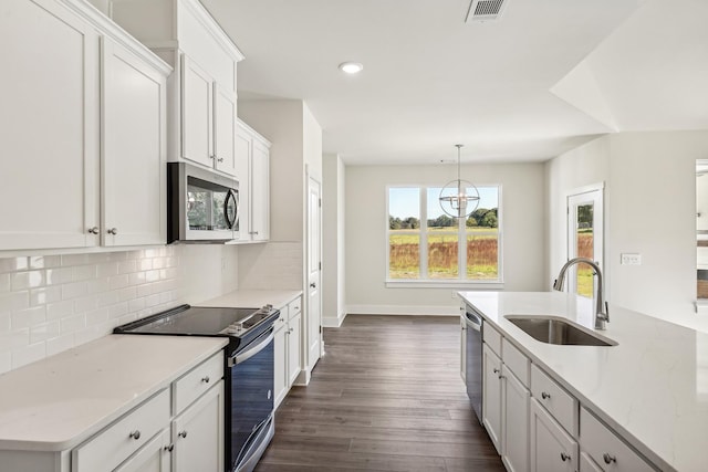 kitchen featuring white cabinetry, sink, light stone counters, and appliances with stainless steel finishes