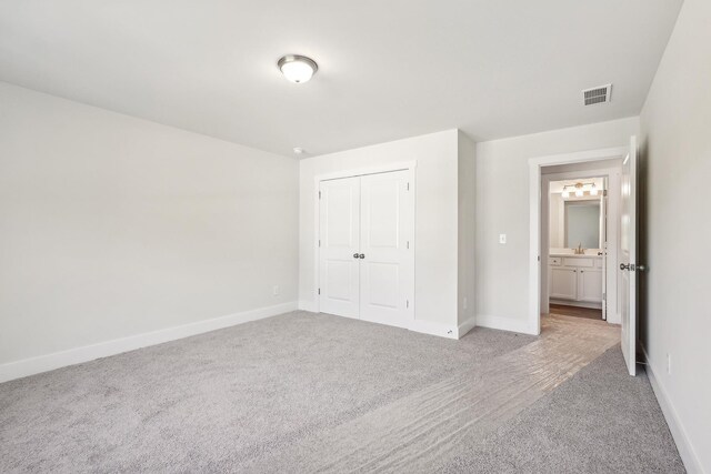 unfurnished bedroom featuring a closet and carpet flooring