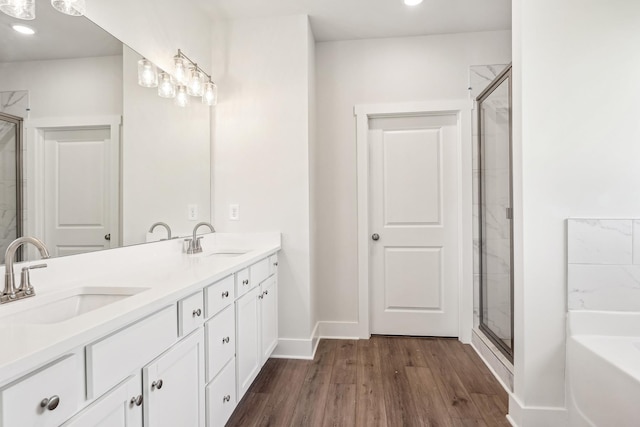 bathroom featuring wood-type flooring, shower with separate bathtub, and vanity