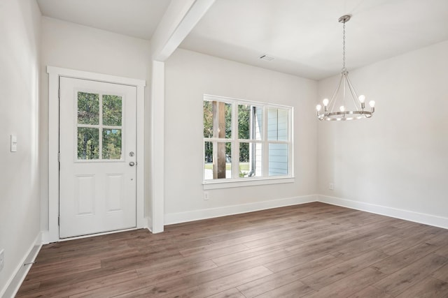 foyer with dark hardwood / wood-style floors, a notable chandelier, and beam ceiling