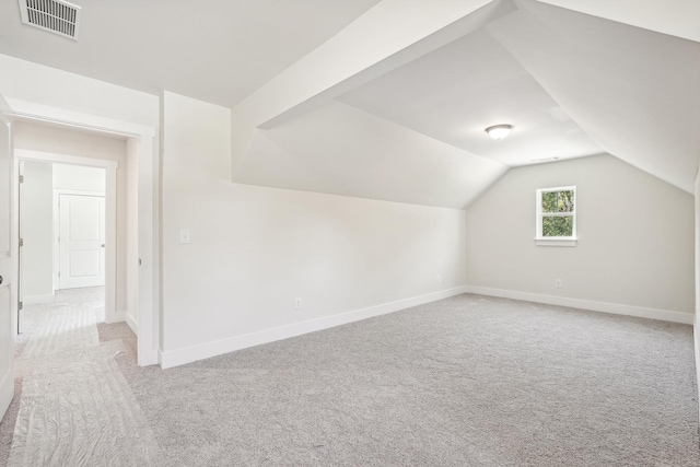 bonus room with light colored carpet and lofted ceiling