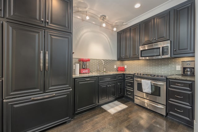 kitchen featuring sink, light stone counters, tasteful backsplash, dark hardwood / wood-style floors, and stainless steel appliances