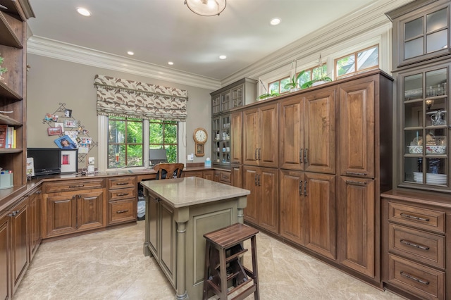 kitchen featuring light stone countertops, a breakfast bar area, ornamental molding, and a center island