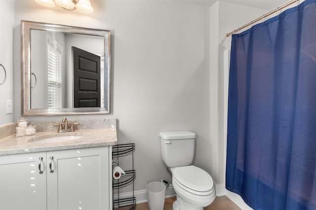 bathroom with walk in shower, vanity, and toilet