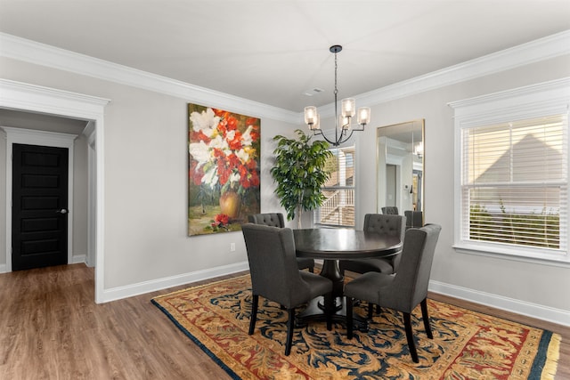 dining area with dark hardwood / wood-style flooring, ornamental molding, and a chandelier