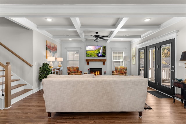 living room featuring ceiling fan, coffered ceiling, a large fireplace, dark hardwood / wood-style flooring, and beamed ceiling