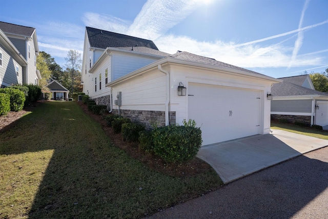 view of property exterior with a garage and a lawn