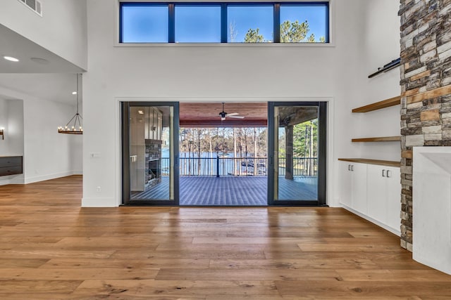 entrance foyer featuring a high ceiling, visible vents, wood finished floors, and baseboards