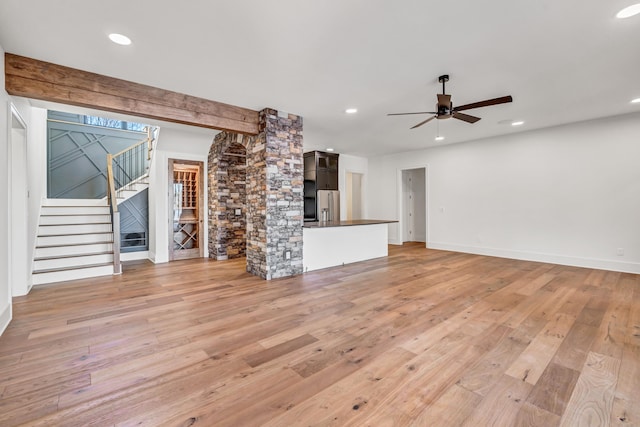 unfurnished living room featuring recessed lighting, light wood finished floors, stairway, and ceiling fan