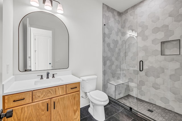 bathroom featuring tile patterned flooring, toilet, a stall shower, and vanity