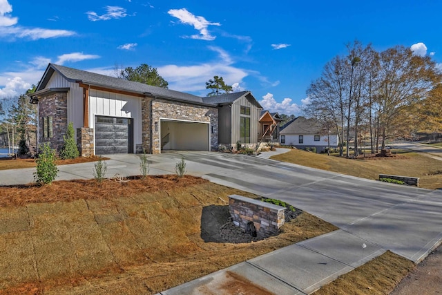 view of front facade featuring a garage, stone siding, board and batten siding, and driveway