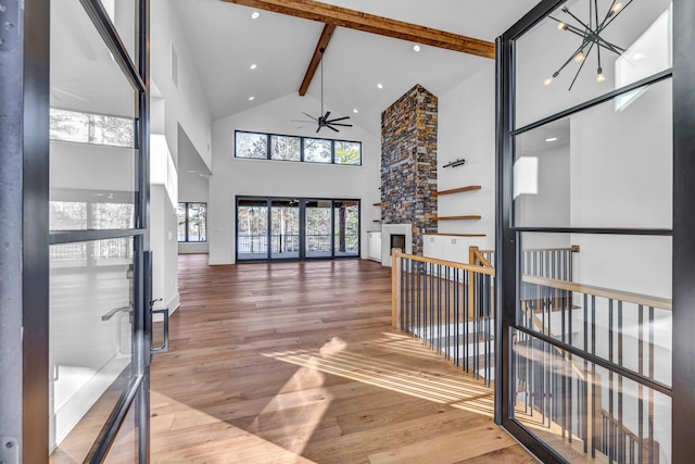 corridor featuring high vaulted ceiling, beam ceiling, wood finished floors, and visible vents