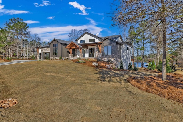 view of front of home with stone siding and a front lawn