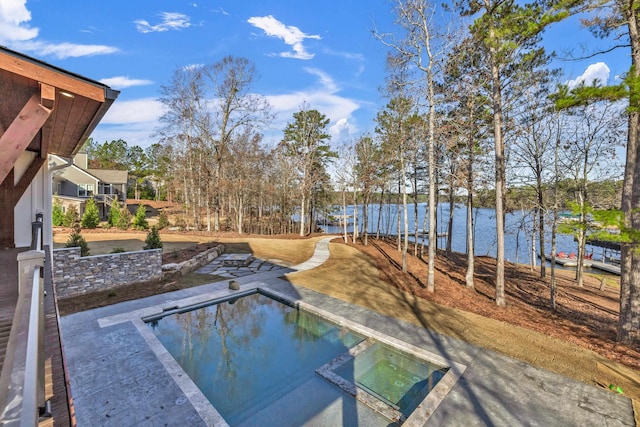 view of swimming pool featuring a water view and a pool with connected hot tub