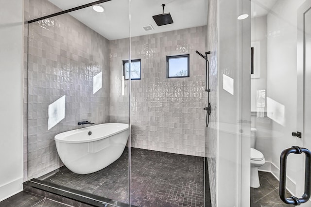 bathroom with toilet, a stall shower, visible vents, and a freestanding tub