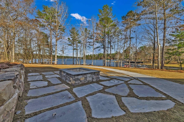 view of pool with a fire pit, a water view, and a patio area