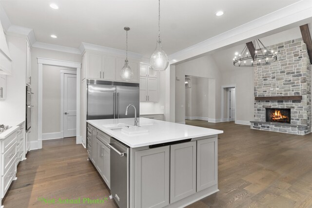 kitchen featuring an island with sink, appliances with stainless steel finishes, light countertops, and a sink