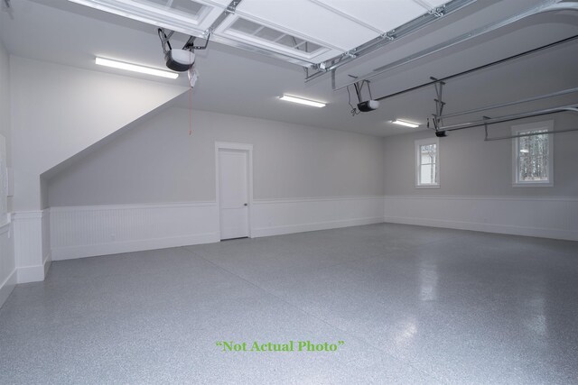 garage with a wainscoted wall and a garage door opener