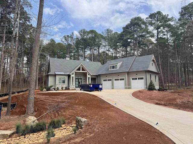 view of front of house with driveway, an attached garage, and a shingled roof