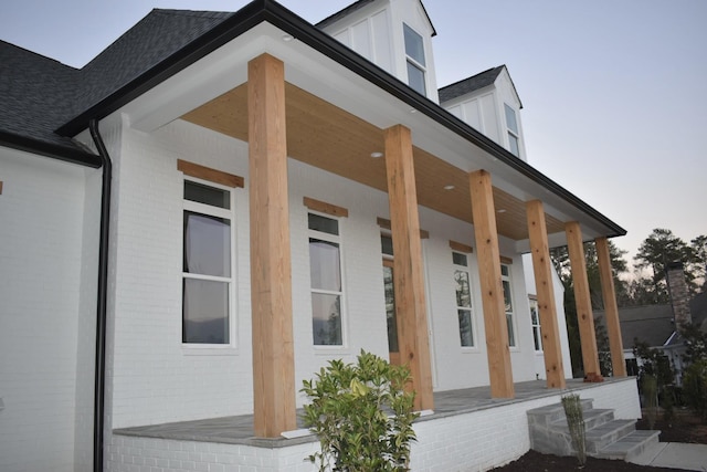 property exterior at dusk featuring a porch