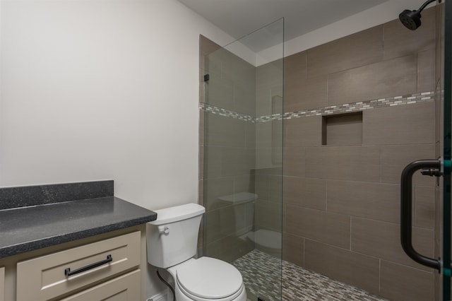 bathroom featuring a stall shower, toilet, and vanity