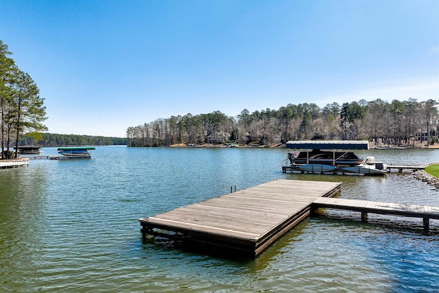 dock area with a water view and a wooded view