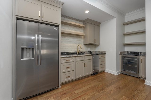 kitchen with ornamental molding, open shelves, wood finished floors, stainless steel fridge, and wine cooler