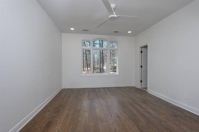 empty room with dark wood-style floors, visible vents, recessed lighting, and baseboards