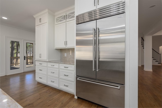 kitchen with stainless steel built in fridge, tasteful backsplash, dark wood-type flooring, and ornamental molding