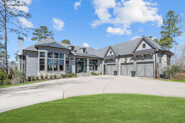 view of front of property with concrete driveway, a standing seam roof, metal roof, stone siding, and a front lawn