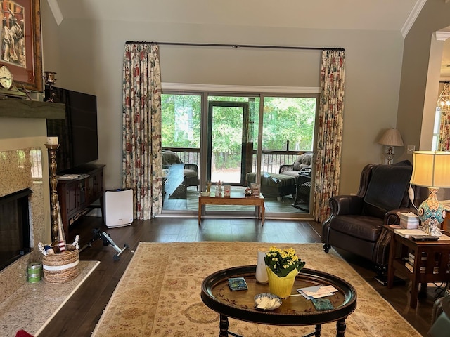 living room featuring crown molding, a high end fireplace, and dark hardwood / wood-style flooring