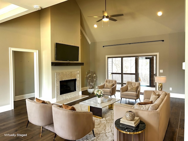 living room featuring ceiling fan, high vaulted ceiling, a high end fireplace, and dark hardwood / wood-style floors