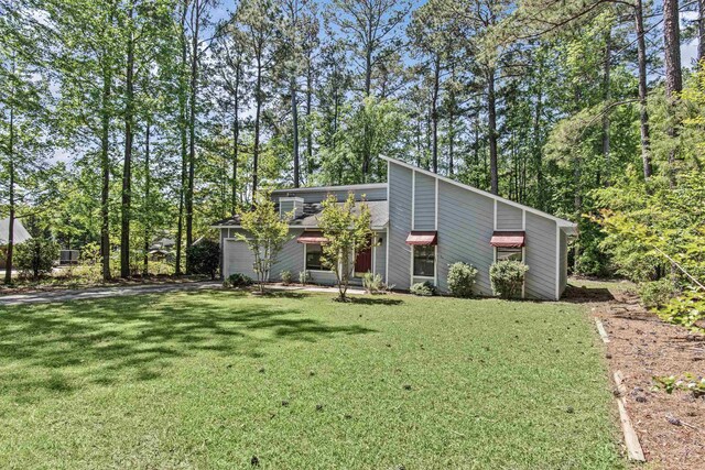 108 Ashwood Pt, Eatonton, GA 31024 - mid-century home with a front lawn, driveway, an attached garage, and roof with shingles