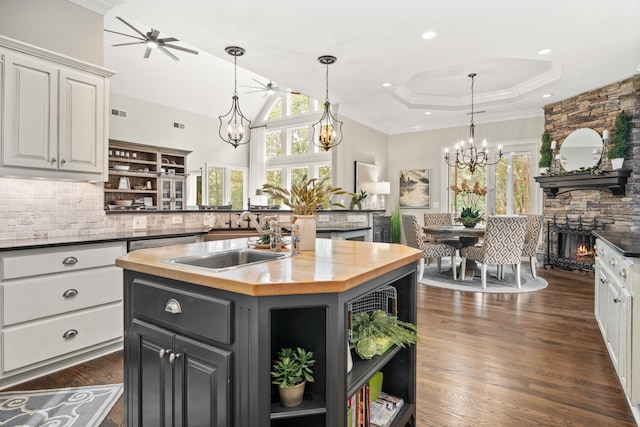 1011 Cartwright Ln, Greensboro, GA 30642 - kitchen with butcher block countertops, open shelves, white cabinets, a chandelier, and a towering ceiling