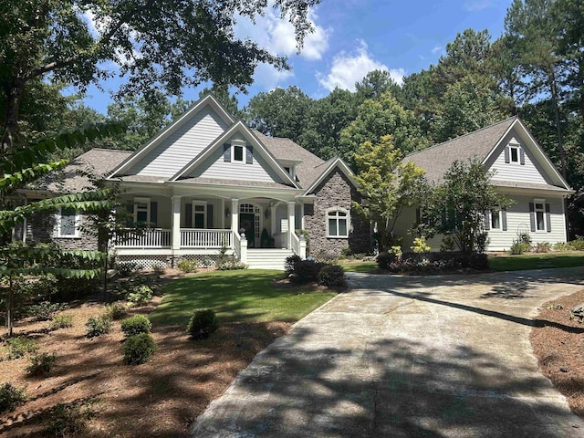 1011 Cartwright Ln, Greensboro, GA 30642 - view of front facade featuring covered porch, stone siding, concrete driveway, a front lawn, and roof with shingles