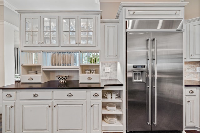 1011 Cartwright Ln, Greensboro, GA 30642 - kitchen with built in refrigerator, tasteful backsplash, white cabinets, dark countertops, and ornamental molding