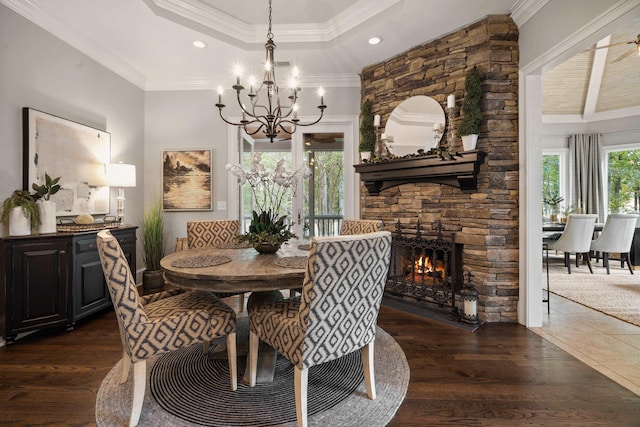 1011 Cartwright Ln, Greensboro, GA 30642 - dining room with a chandelier, a stone fireplace, crown molding, dark wood-type flooring, and a raised ceiling