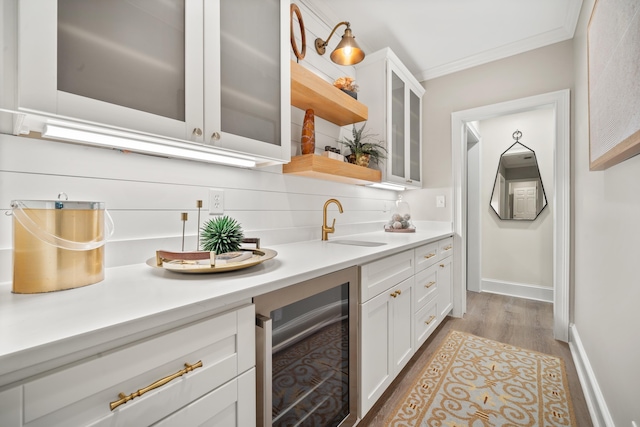 1011 Cartwright Ln, Greensboro, GA 30642 - indoor wet bar featuring beverage cooler, ornamental molding, light wood-style floors, and decorative backsplash