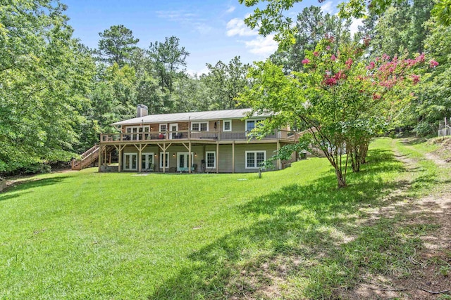 rear view of house with a deck and a lawn