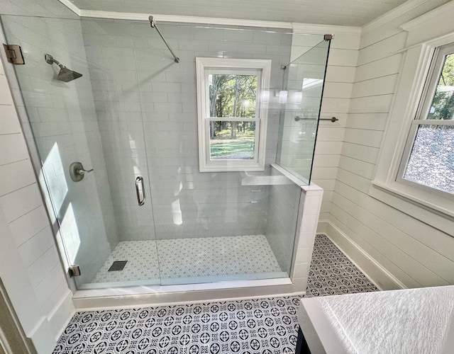 bathroom with a shower with door and tile patterned flooring