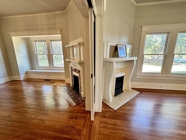 unfurnished living room with plenty of natural light, ornamental molding, and dark hardwood / wood-style floors