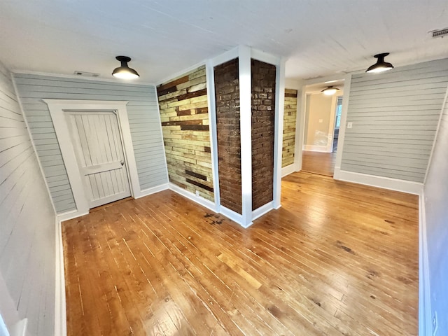 spare room with wood-type flooring and wooden walls