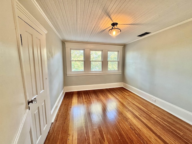 empty room with crown molding, hardwood / wood-style floors, and wooden ceiling