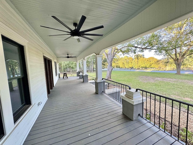 deck featuring ceiling fan and a lawn