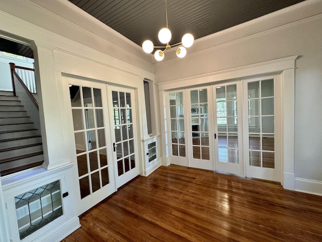 interior space with french doors, ornamental molding, dark hardwood / wood-style floors, and a chandelier