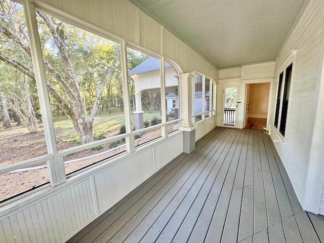 unfurnished sunroom with decorative columns